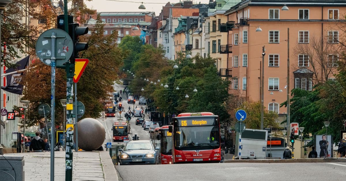 Gata på Södermalm med bussar och gående — innerstadskörning kräver körfältsval i god tid.
