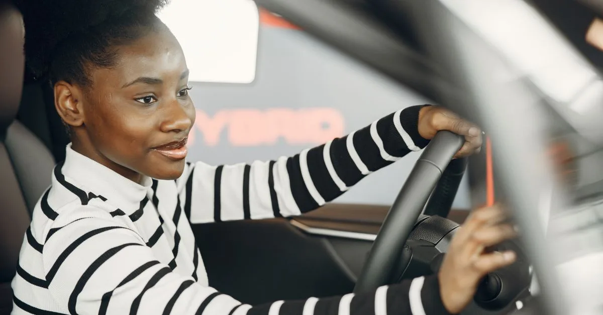 A smiling driving student behind the wheel — illustrative photo for driving lessons in English.