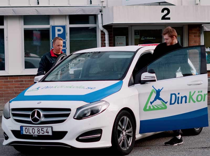 En av Din Körskolas egna bilar utanför trafikskolan, med skolans dekal på sidan