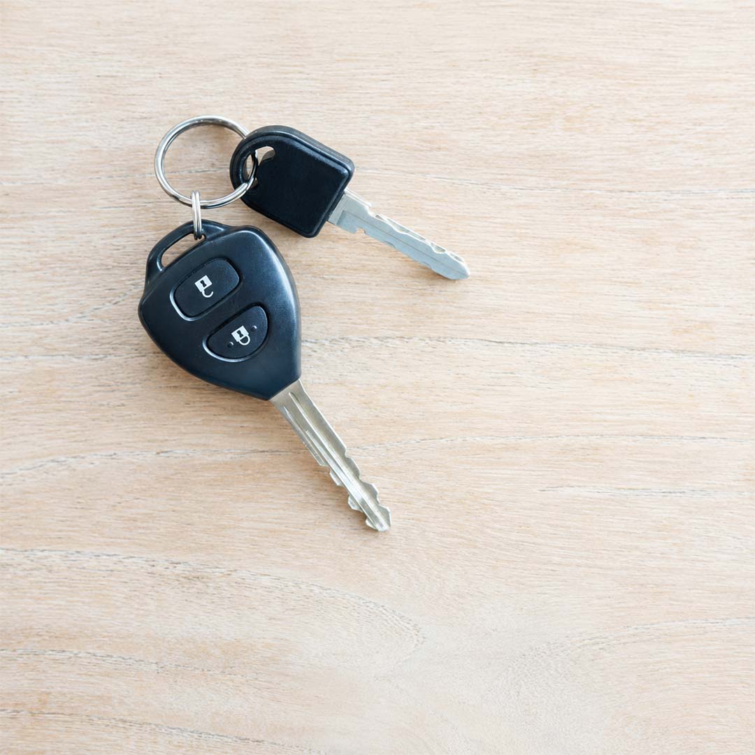 Car key next to a stopwatch on a desk,
